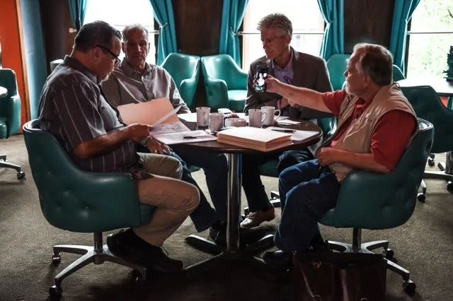 The GDI investigators reviewing case files together at a round table